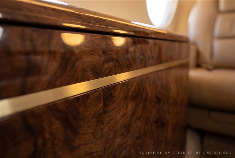 Walnut veneer cabinetry detail with brass inlay
