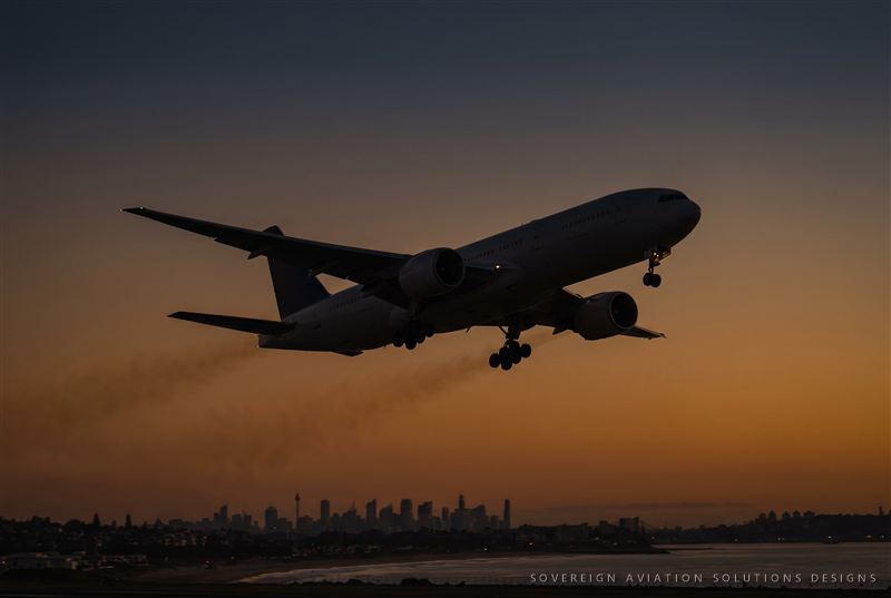 Widebody aircraft climbing after takeoff at dusk